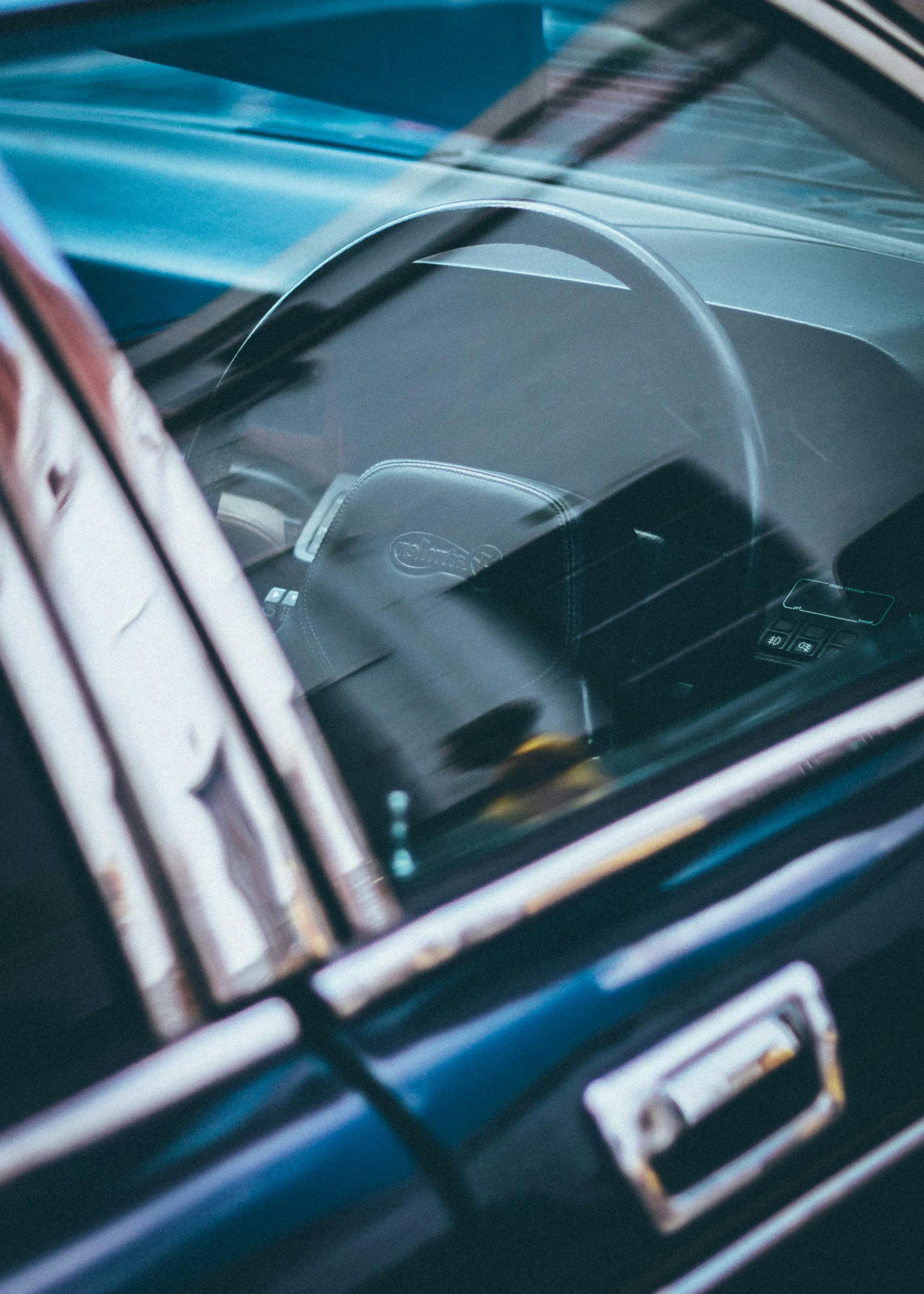 a dog sitting in the driver's seat of a car, an album cover, by Adam Marczyński, unsplash, les automatistes, 1 9 7 0 s car window closeup, blue tinted, glass and metal : : peugot onyx, full view of a sport car