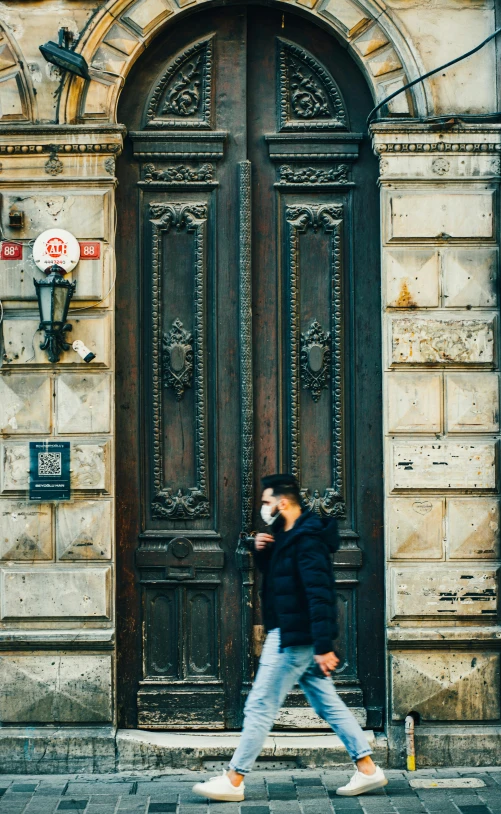 a man walking down a street past a wooden door, by Adam Marczyński, pexels contest winner, renaissance, splendid haussmann architecture, teenage girl, square, man wearing a closed cowl