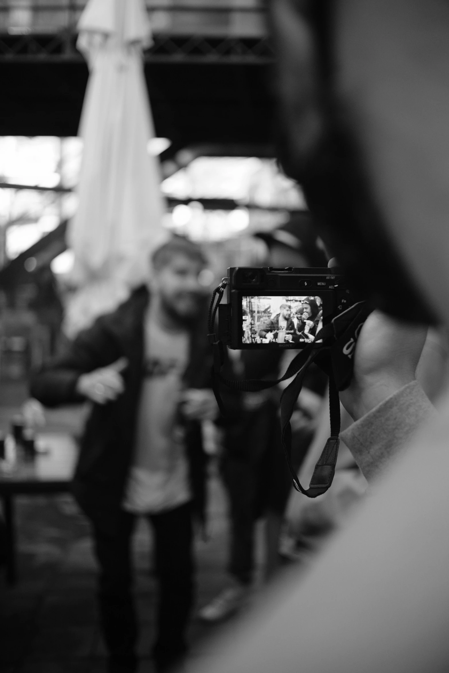 a black and white photo of a person holding a camera, happening, smartphone footage, in a workshop, cinematic outfit photo, blurry footage