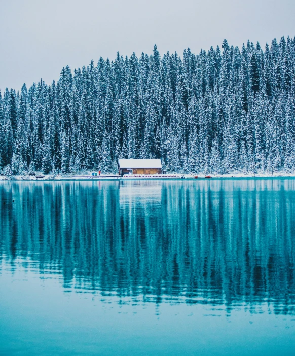 a cabin sitting on top of a lake next to a forest, by Sebastian Spreng, pexels contest winner, hurufiyya, blue liquid and snow, banff national park, 4k serene, detail shots