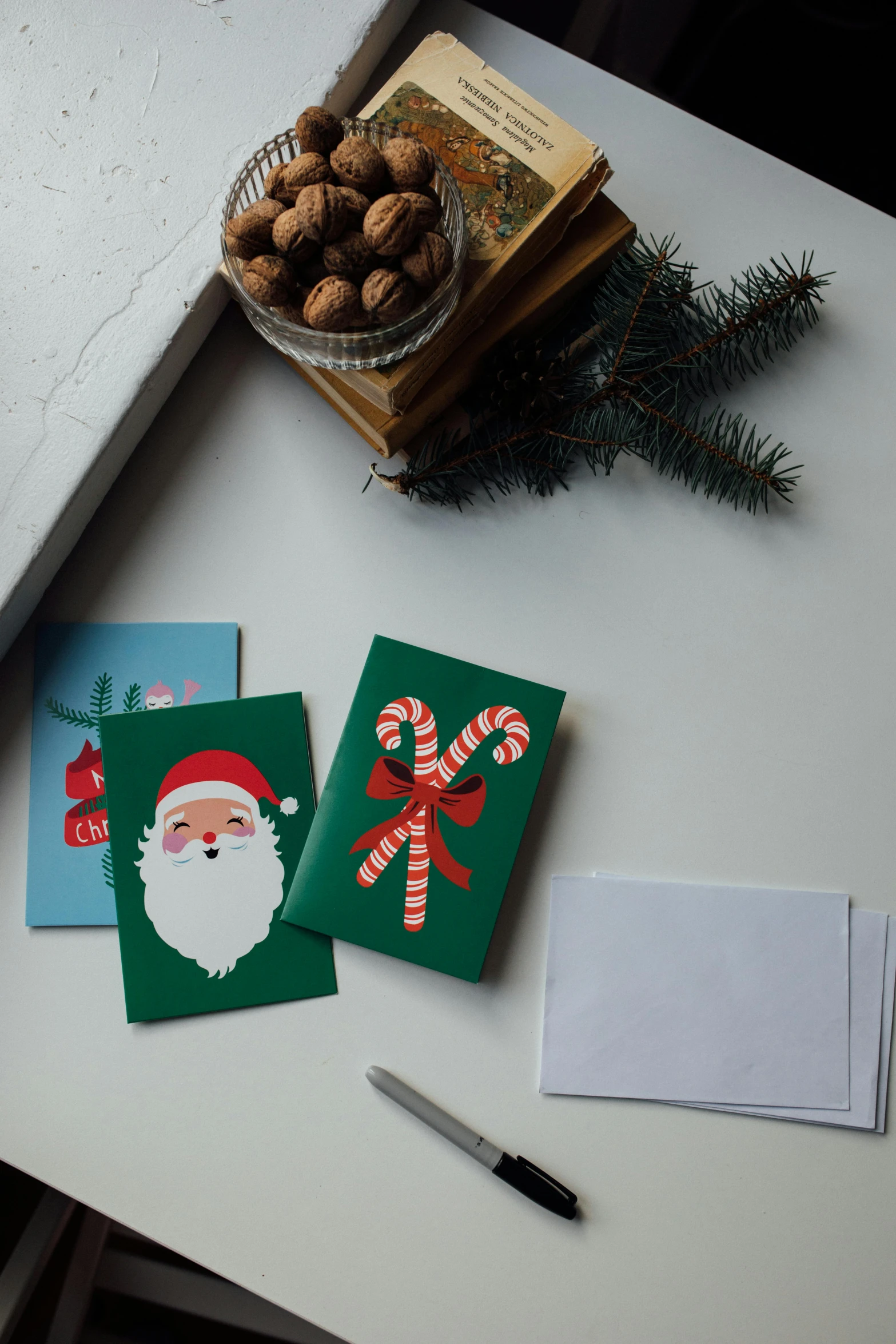 a couple of christmas cards sitting on top of a table, on a gray background, mint, 3 - piece, on a desk