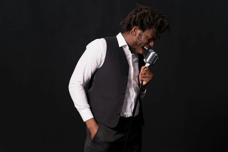 a man in a vest and tie holding a microphone, an album cover, inspired by Charles Martin, pexels contest winner, full body model, ( ( dark skin ) ), photoshoot portrait, ivory and ebony