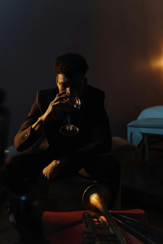 a man sitting on a couch with a trumpet, inspired by Elsa Bleda, pexels contest winner, renaissance, holding glass of wine, dark skinned, 2 1 savage, ( ( theatrical ) )