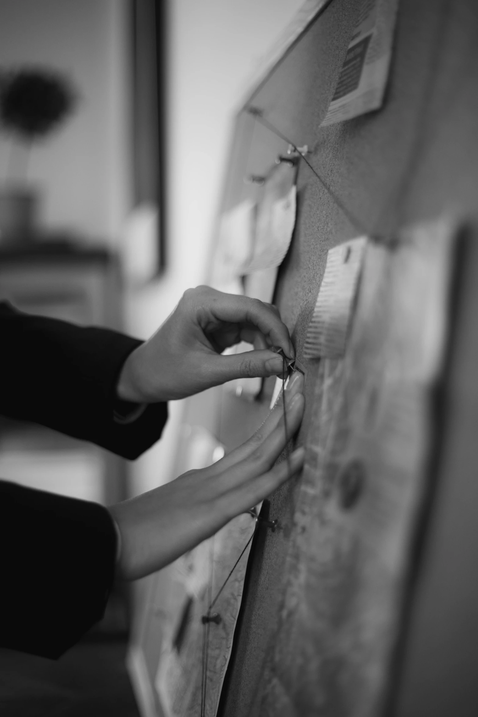 a black and white photo of a person writing on a board, by Felix-Kelly, laces and ribbons, craftsmanship, bespoke, organic detail