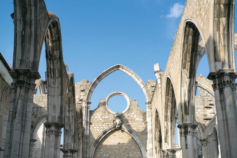 a couple of people that are standing in a building, an album cover, pexels contest winner, baroque, ruined gothic cathedral, santiago calatrava, blue sky, high arches