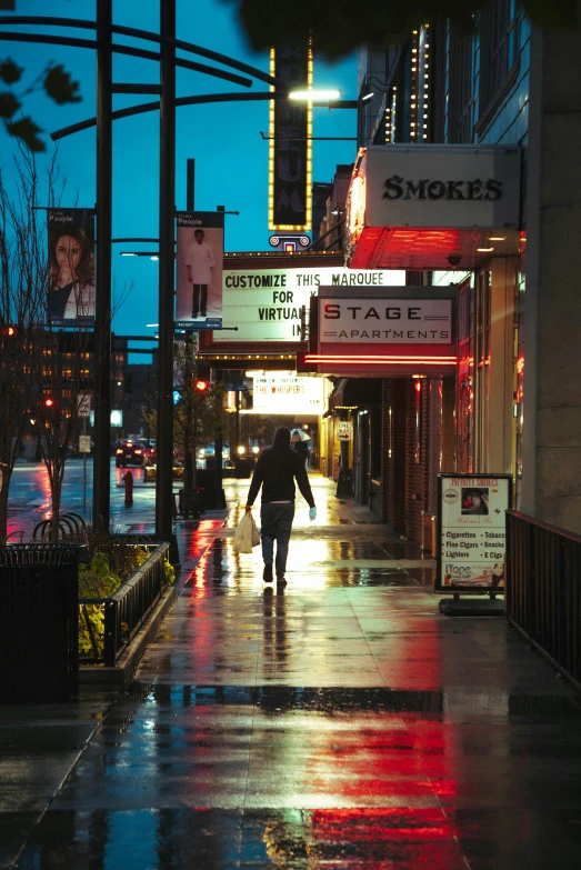 a person walking down a wet sidewalk at night, theater, late afternoon, washington main street, billboard image