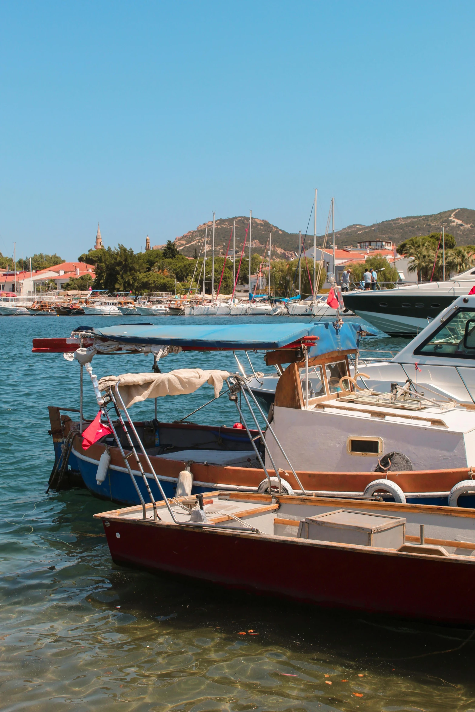 a number of boats in a body of water, a picture, inspired by Wilhelm Marstrand, happening, turkey, docked at harbor, clear and sunny, red roofs