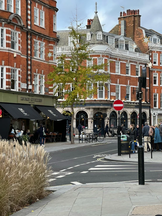 a man riding a bike down a street next to tall buildings, arts and crafts movement, esher, restaurant in background, photo taken in 2 0 2 0, : :