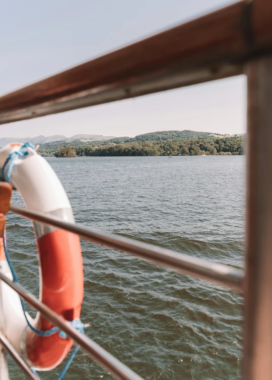 a life preserver on the deck of a boat, pexels contest winner, happening, wide river and lake, medium head to shoulder shot, hills in the background, gushy gills and blush