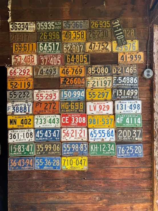 a number of license plates on a wooden wall, by Jessie Algie, 8 k photo, various items, taken on iphone 14 pro, 7 0 s photo