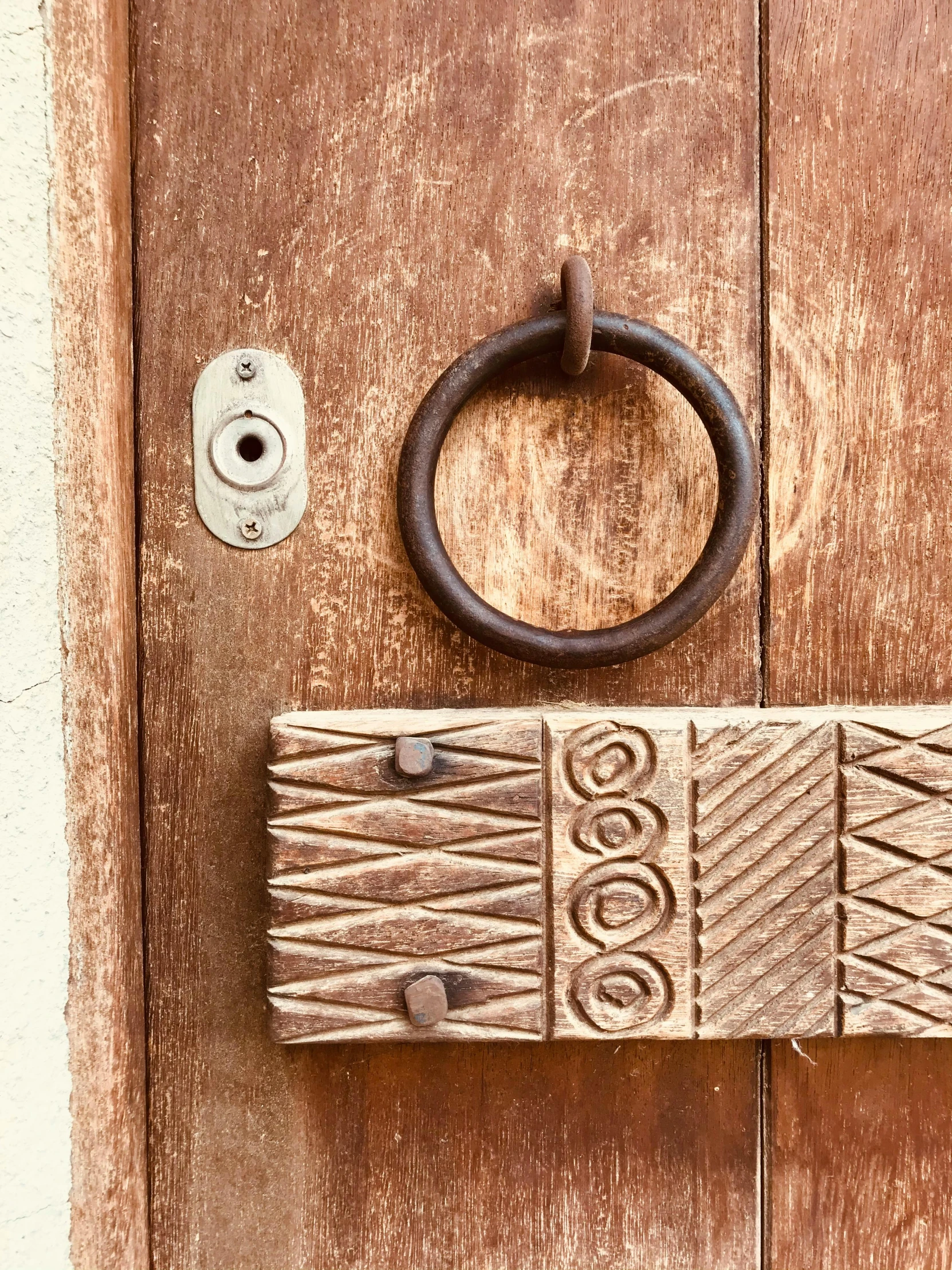 a close up of a door handle on a wooden door, an album cover, inspired by Oluf Høst, trending on unsplash, folk art, shipibo patterns, statue of a cubes and rings, wood block print, maximum natural texture