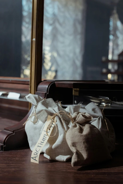 a suitcase sitting on top of a wooden floor next to a window, cg society contest winner, private press, burlap, pouches, historically accurate, celebration of coffee products