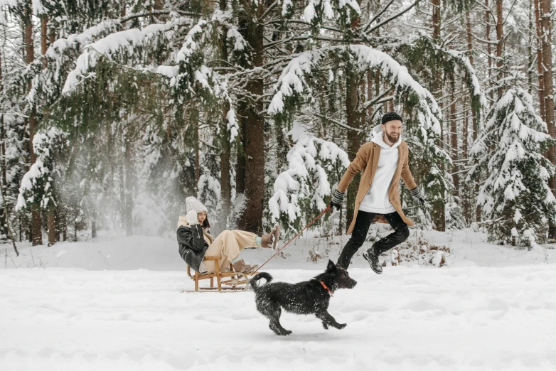 a man running in the snow with a dog and a sled, pexels contest winner, avatar image, picnic, ad image, australian