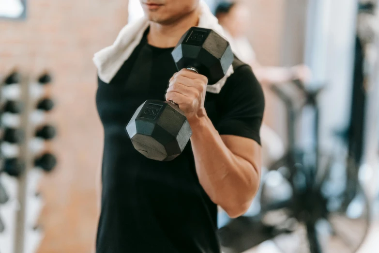 a man holding a pair of dumbs in a gym, pexels contest winner, lachlan bailey, profile image, no - text no - logo, male and female