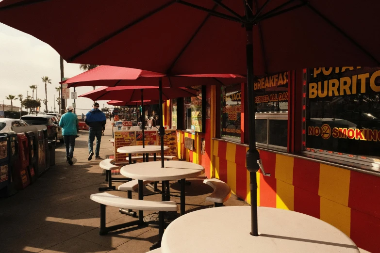 a bunch of tables and umbrellas on a sidewalk, hotdogs, red and yellow, profile image, outdoor fairgrounds