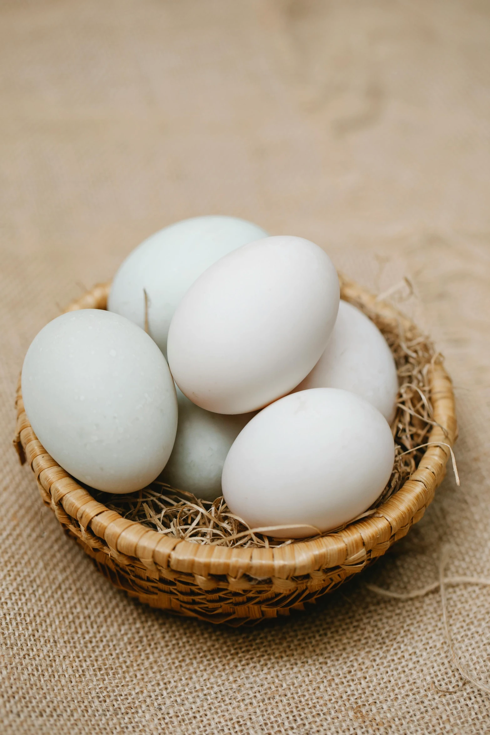 a basket filled with eggs sitting on top of a table, pale milky white porcelain skin, organics, teals, 王琛