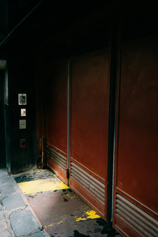 a fire hydrant sitting on the side of a street, an album cover, by Elsa Bleda, elevator doors look like a mouth, 1990s photograph, brown, a 1980s goth nightclub in soho