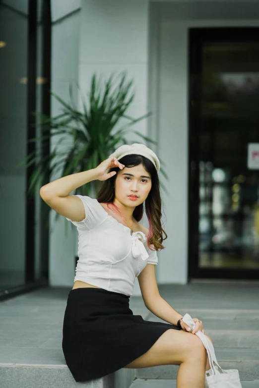 a woman sitting on the steps of a building, unsplash, realism, wearing a headband, south east asian with round face, on a white table, croptop