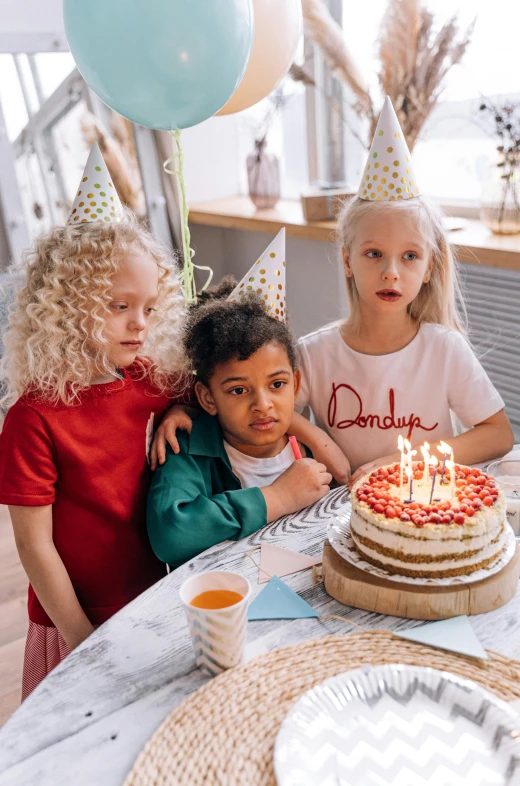 a group of children sitting at a table with a birthday cake, pexels contest winner, happening, a blond, background image, modelling, thumbnail