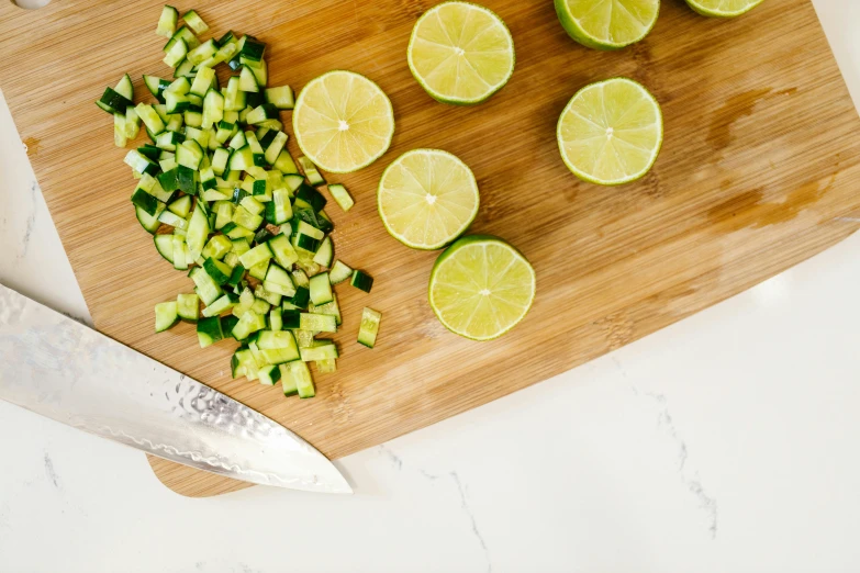 a cutting board topped with sliced limes and a knife, by Carey Morris, pexels, cucumber, salad, background image, listing image