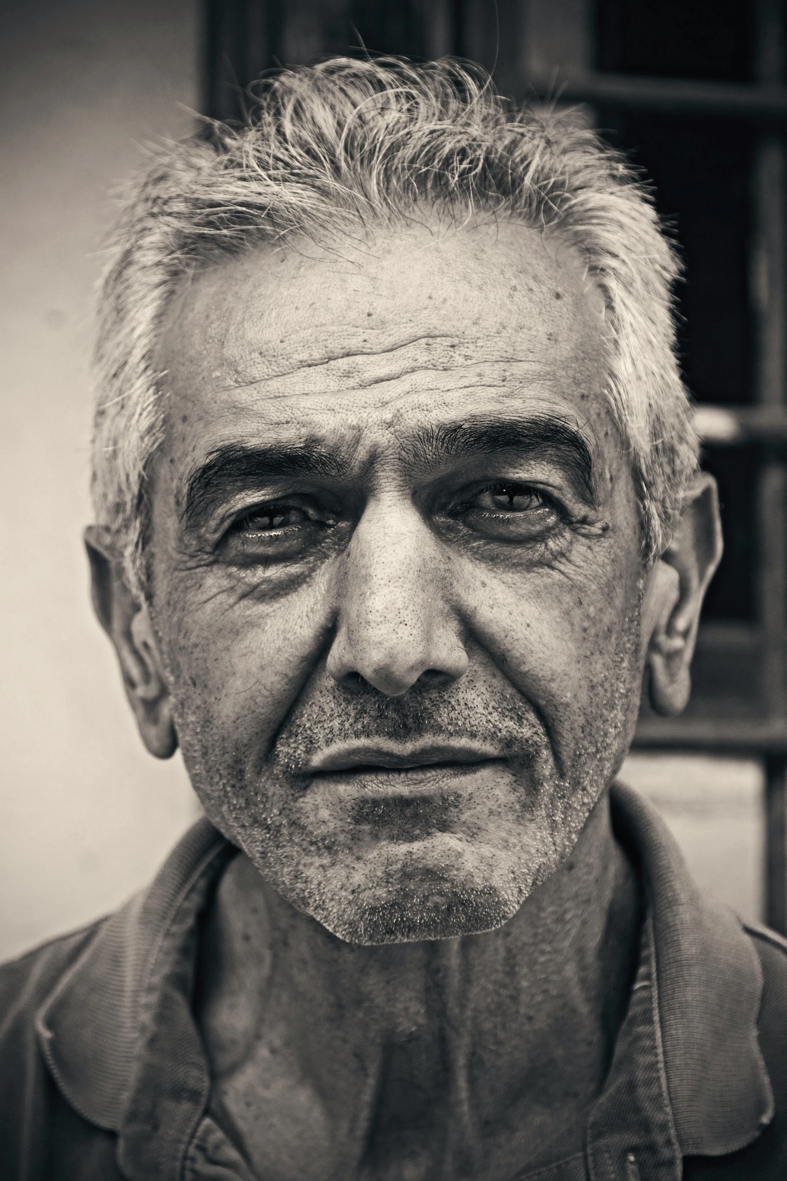 a black and white photo of a man, by Ibrahim Kodra, gray hair, middle eastern, color photograph portrait 4k, slightly smiling