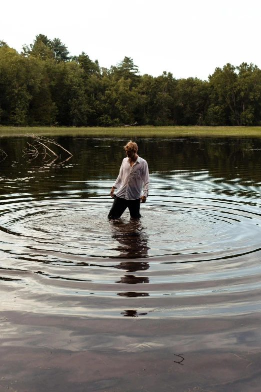 a person in a body of water with a frisbee, by Robert Storm Petersen, unsplash, land art, deep sinkhole, minn, julia hetta, standing in a maelstrom