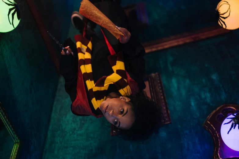 a woman laying on the floor with a bat in her hand, inspired by Hermione Hammond, pexels contest winner, hurufiyya, in the gryffindor common room, portrait willow smith, production photo, upside - down