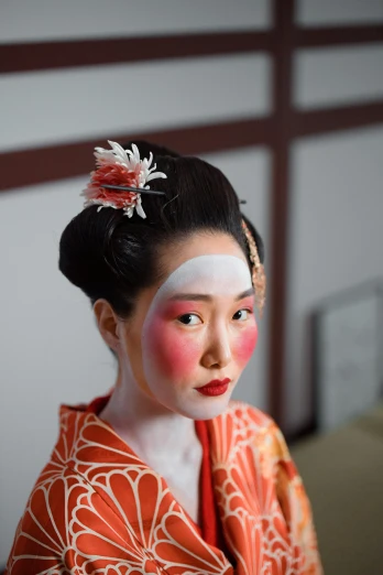 a woman in a kimono with a flower in her hair, a portrait, inspired by Uemura Shōen, trending on unsplash, white facepaint, square, red cheeks, photographed for reuters