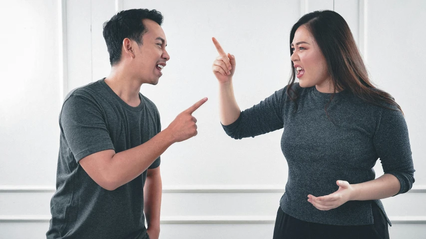 a man and a woman standing next to each other, trending on pexels, realism, angry and pointing, asian female, fighting with angles, npc talking