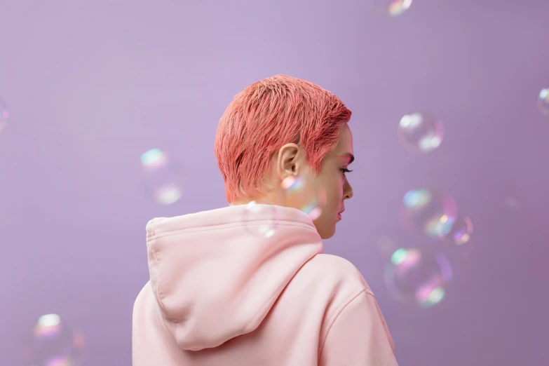 a man in a pink hoodie standing in front of soap bubbles, an album cover, inspired by Yanjun Cheng, trending on pexels, cute girl with short pink hair, profile view, color ( sony a 7 r iv, facing away