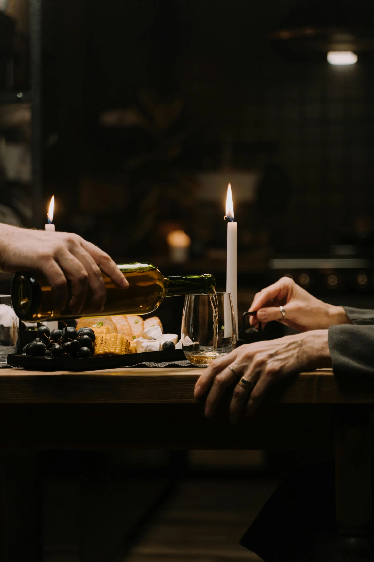 a couple of people that are sitting at a table, a still life, by Jesper Knudsen, pexels contest winner, renaissance, holding a candle, holding wine bottle, gif, nightlife