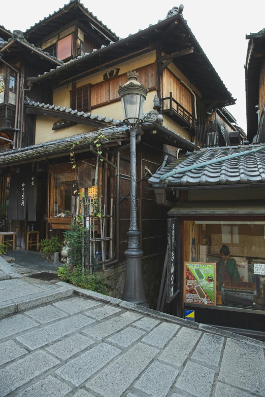 a couple of buildings that are next to each other, a picture, inspired by Kaii Higashiyama, ukiyo-e, baroque winding cobbled streets, peaked wooden roofs, photo for a store, looking around a corner