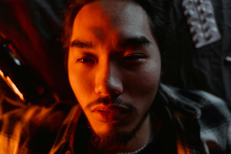 a close up of a person with a cell phone, an album cover, inspired by Liam Wong, pexels contest winner, photorealism, realistic face moody lighting, tengri, fire behind him, discord profile picture