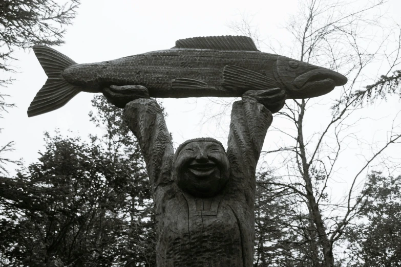 a statue of a man holding a fish above his head, by Jaakko Mattila, queen of the forest, large smile, proudly holding a salmon, indigenous