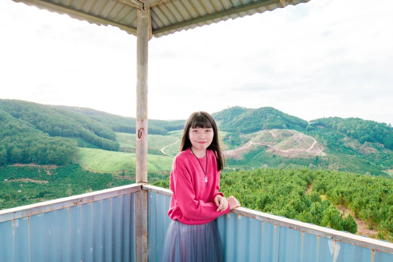 a girl standing on a balcony with mountains in the background, an album cover, inspired by Ni Yuanlu, unsplash, in pink forest, portrait n - 9, kodak portra, sakimichan hdri