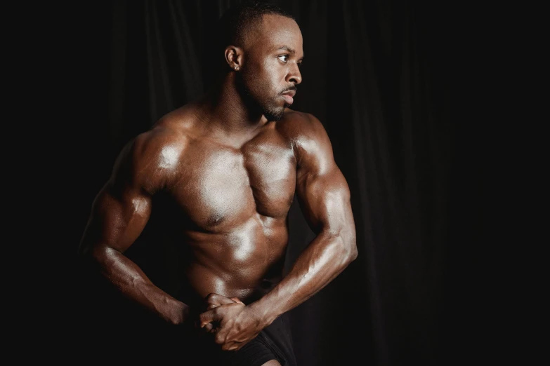 a man posing for a picture in front of a black background, by Sam Charles, pexels contest winner, figuration libre, ifbb fitness body, oiled skin, ebony skin, 2 0 0 0's photo