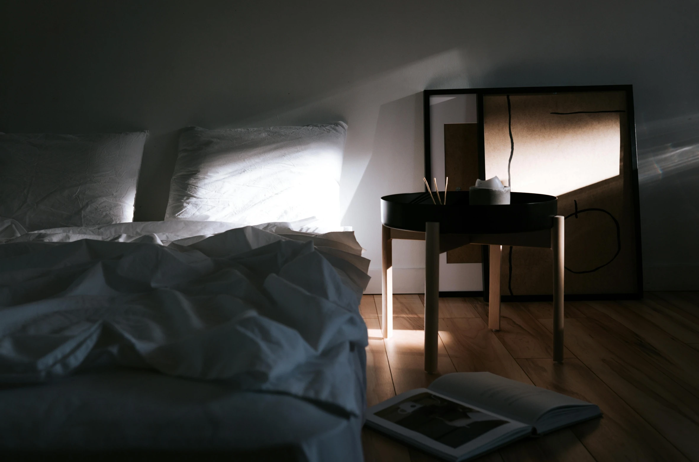 a bed room with a neatly made bed and a night stand, inspired by Elsa Bleda, unsplash, light and space, beds of shadows, table in front with a cup, play of light, subsurface scandering