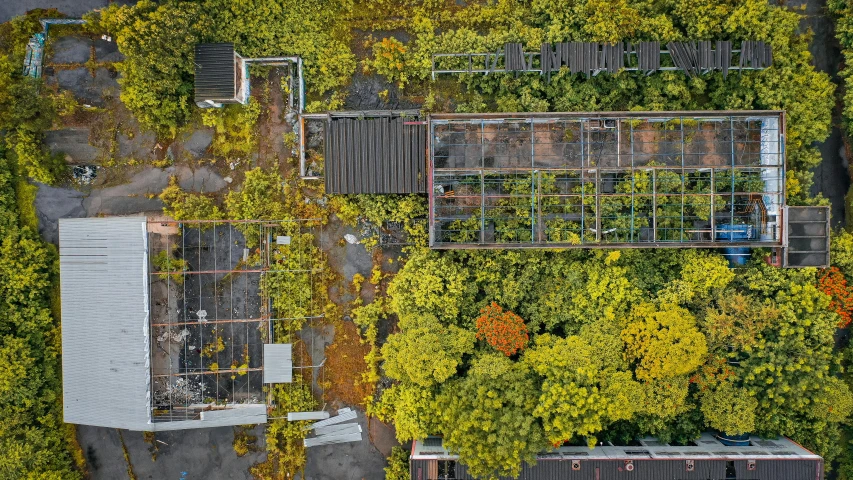 an aerial view of a building surrounded by trees, by Carey Morris, unsplash, conceptual art, autumn overgrowth, soviet yard, ((rust)), lush brooklyn urban landscaping