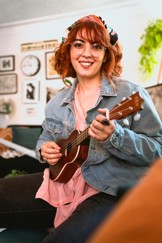 a woman sitting on a couch playing a guitar, ukulele, headshot profile picture, promo image, a redheaded young woman