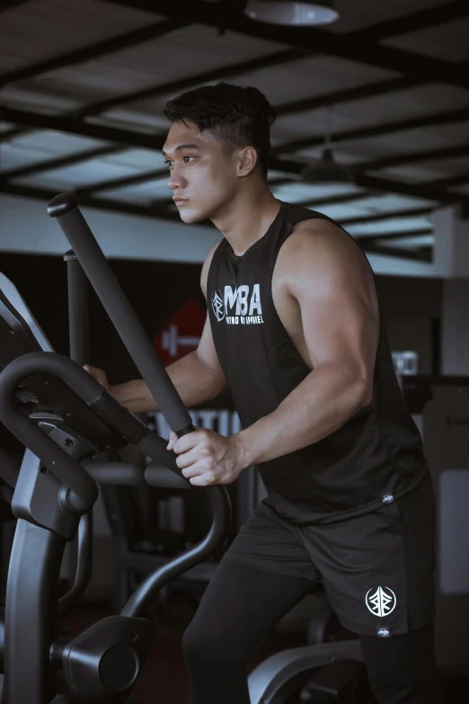 a man on a stationary bike in a gym, by Robbie Trevino, featured on instagram, black tank top, bali, profile image, thumbnail