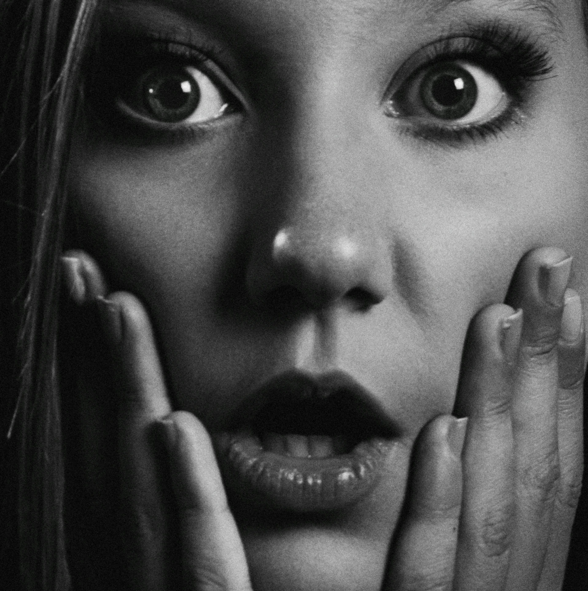 a black and white photo of a woman with her hands on her face, by Adam Marczyński, pixabay, surrealism, big eyes!!!!!!!!, anya taylor - joy vampire queen, sydney sweeney, looking surprised