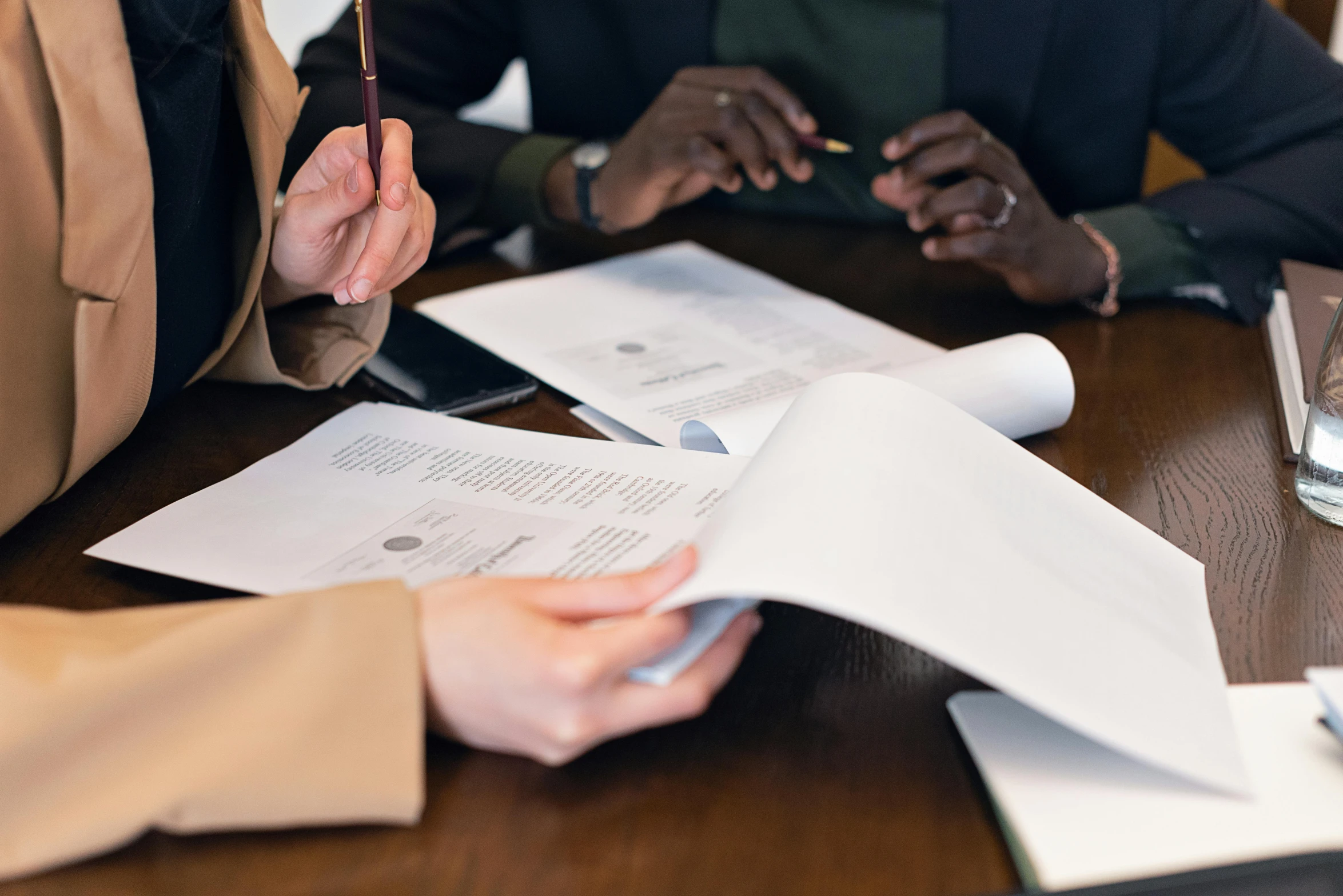 a couple of people sitting at a table with papers, on a table