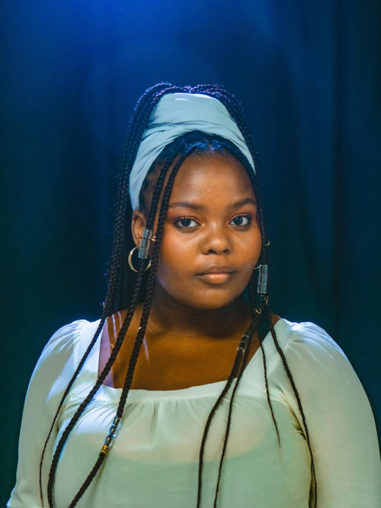 a woman with dreadlocks posing for a picture, an album cover, teal studio backdrop, face is wrapped in a black scarf, dark and dim lighting, nettie wakefield