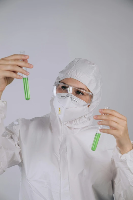 a woman in a protective suit holding two test tubes, shutterstock, wearing white silk hood, avatar image, a green, nanogirlv 2