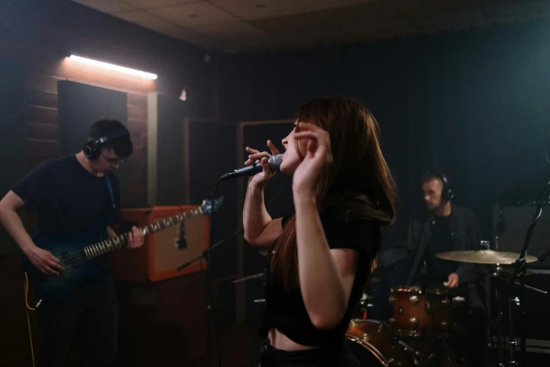 a woman that is standing in front of a microphone, an album cover, pexels contest winner, antipodeans, band playing, in a studio, 15081959 21121991 01012000 4k, performing a music video