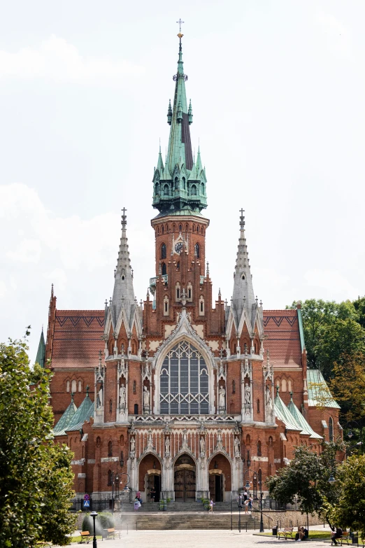 a large red brick building with a green steeple, inspired by Mihály Munkácsy, stanisław, cathedrals, front face, large crown