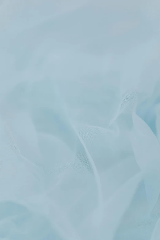 a teddy bear sitting on top of a bed covered in a blue sheet, opalescent mist, blue-fabric, ((blue)), detailed product shot