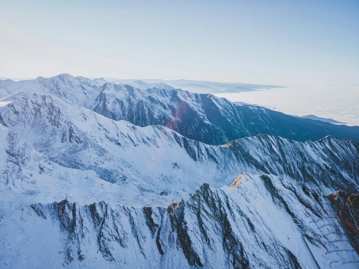 a group of people standing on top of a snow covered mountain, new zeeland, aerial viewyoji shinkawa, taken at golden hour, 4k press image