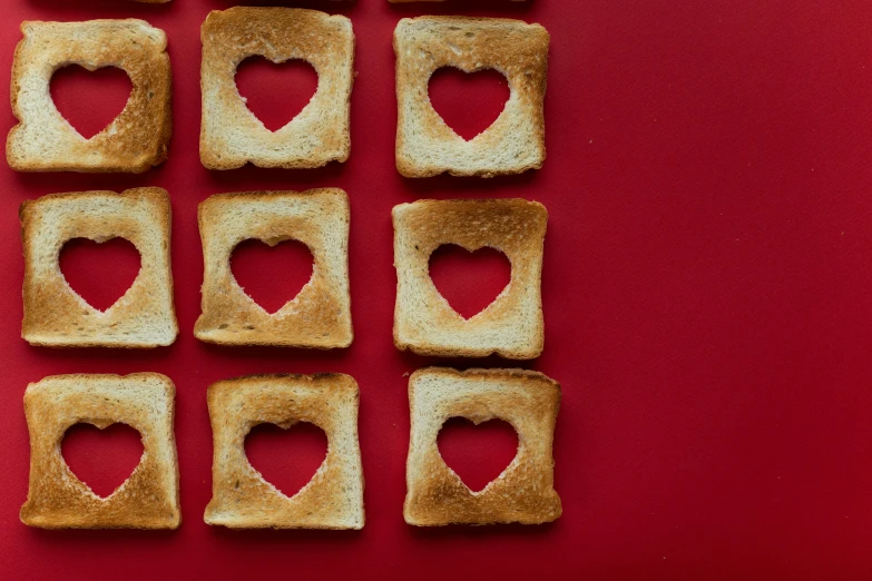 a number of pieces of toast with hearts cut out of them, by Sylvia Wishart, trending on pexels, on a red background, square lines, cheerios, healthcare