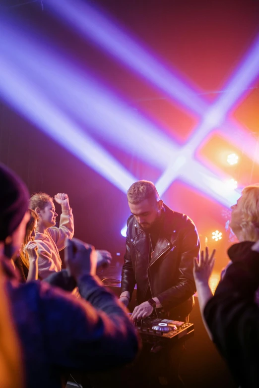 a group of people standing next to each other at a concert, by Matt Cavotta, happening, dj at a party, holy lights, a blond, profile image